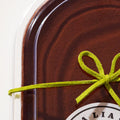 A close-up of the Vegan Tiramisù packaging, highlighting the smooth cocoa powder topping and the green bow detail.