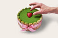 Nonna Lia Cake Matcha with hand reaching for strawberry